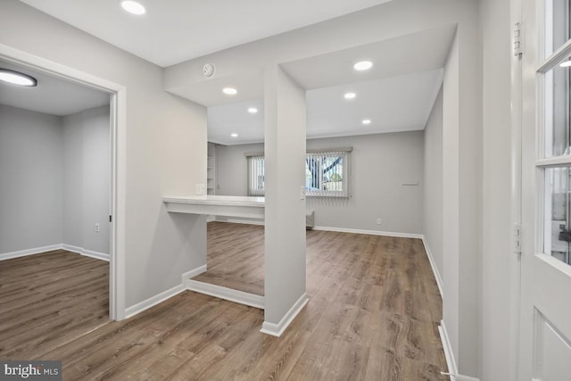 hallway featuring recessed lighting, wood finished floors, and baseboards