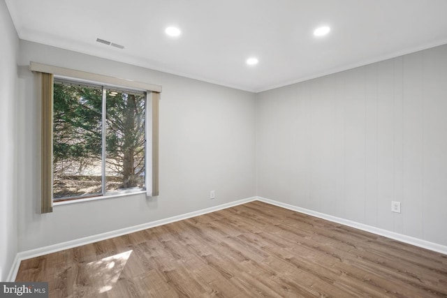 unfurnished room with recessed lighting, wood finished floors, visible vents, and baseboards