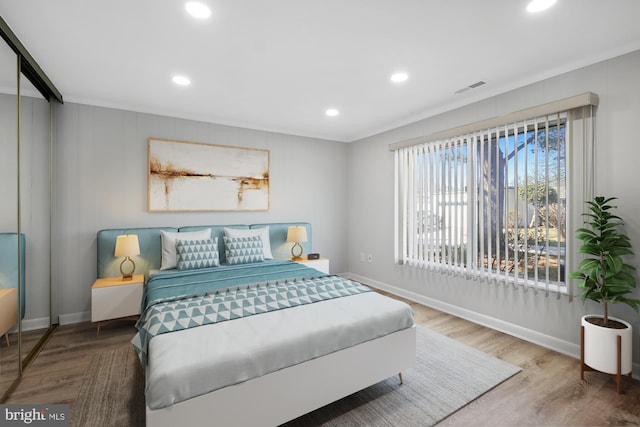 bedroom with visible vents, baseboards, and wood finished floors