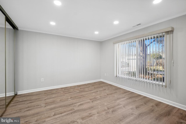 unfurnished room featuring recessed lighting, wood finished floors, visible vents, and baseboards