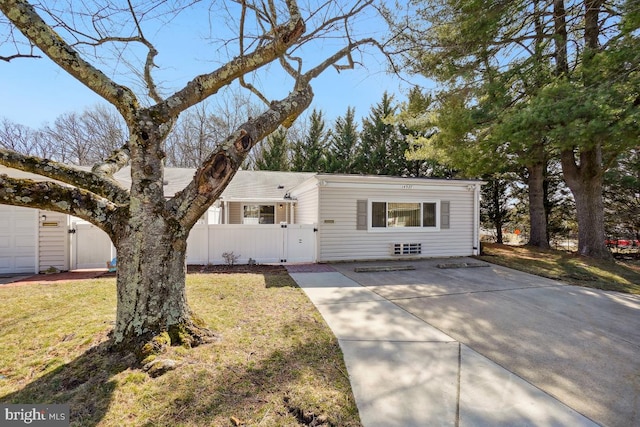 view of front of property featuring fence, a front lawn, and a gate