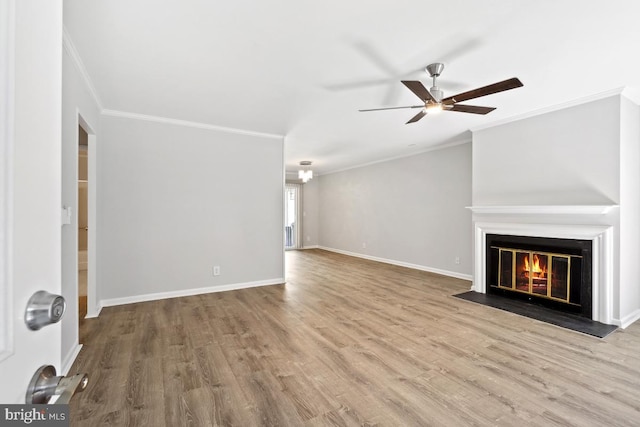 unfurnished living room featuring baseboards, a fireplace with flush hearth, ornamental molding, wood finished floors, and a ceiling fan