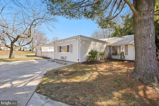 view of property exterior with a lawn and concrete driveway