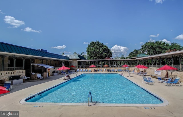 pool with a patio area and fence