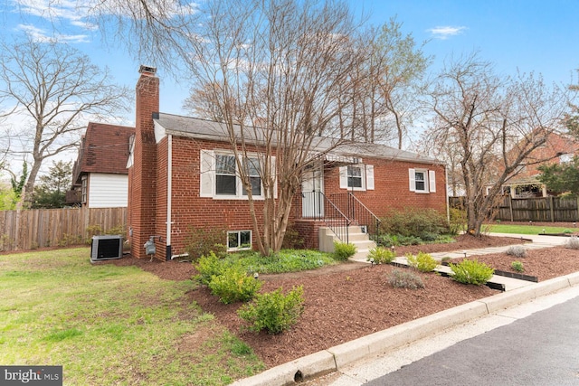101 S Lexington St, Arlington, VA 22204 - view of front facade featuring brick siding, a chimney, and central AC unit