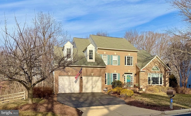 view of front of house featuring driveway, a garage, roof with shingles, fence, and brick siding