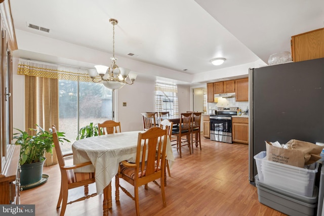 dining room with a chandelier, visible vents, and light wood finished floors