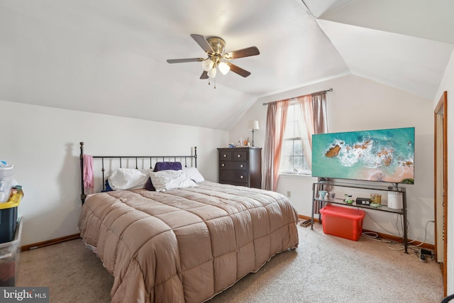 bedroom featuring a ceiling fan, light colored carpet, vaulted ceiling, and baseboards