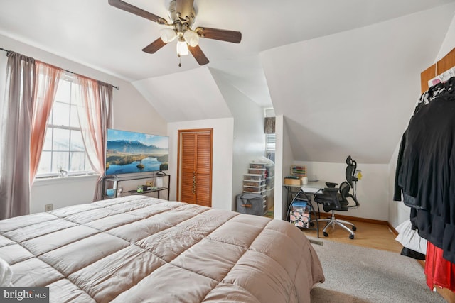 bedroom featuring lofted ceiling, a ceiling fan, baseboards, and a closet