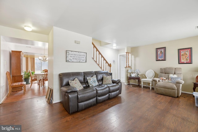 living area featuring dark wood-style floors, baseboards, stairway, and a chandelier