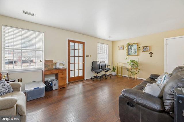 living area featuring dark wood-style flooring, visible vents, and baseboards