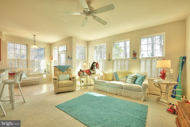 interior space with carpet, a ceiling fan, and baseboards