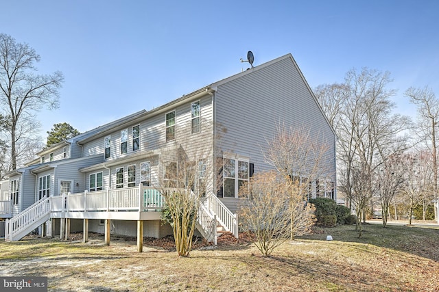 rear view of property featuring stairway and a wooden deck