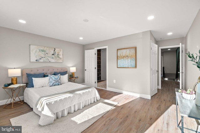 bedroom with recessed lighting, baseboards, and wood finished floors