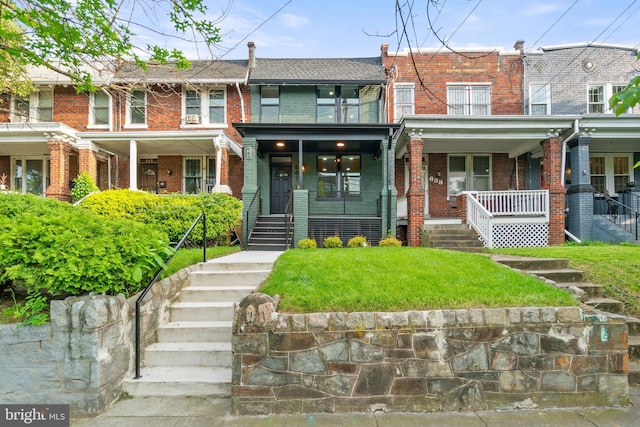 view of property featuring covered porch, stairs, and brick siding