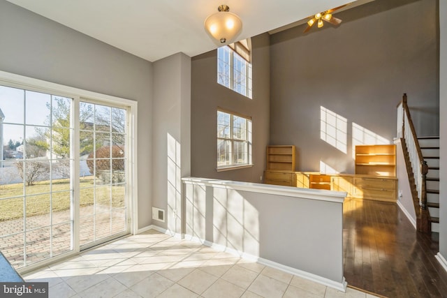 interior space with baseboards, stairway, visible vents, and a healthy amount of sunlight