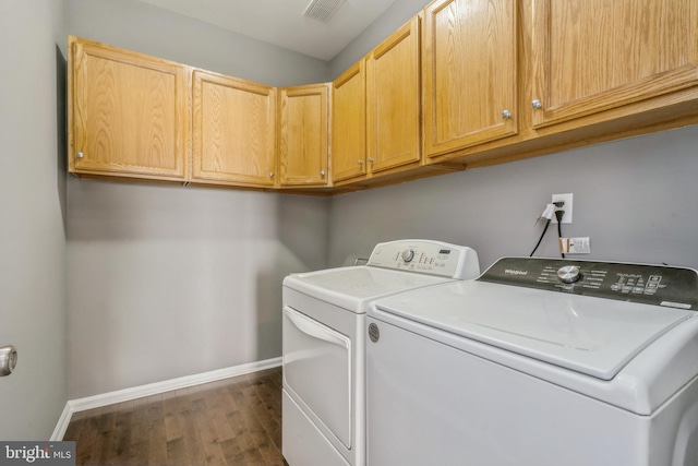 clothes washing area with washer and dryer, cabinet space, visible vents, and baseboards