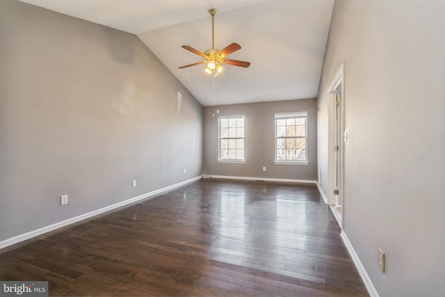 unfurnished room with vaulted ceiling, dark wood-type flooring, a ceiling fan, and baseboards