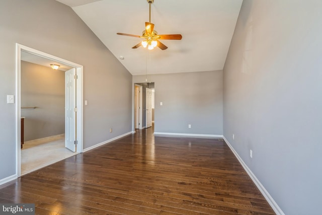 spare room with a ceiling fan, dark wood-style flooring, high vaulted ceiling, and baseboards