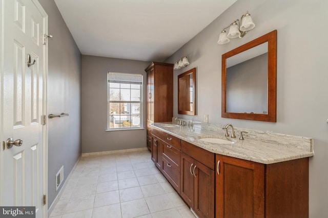 full bath with double vanity, a sink, baseboards, and tile patterned floors