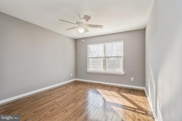 unfurnished room featuring a ceiling fan, baseboards, and wood finished floors