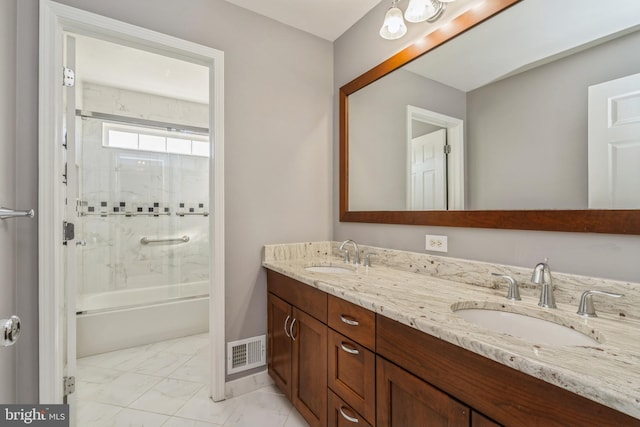 full bath with marble finish floor, shower / bath combination with glass door, visible vents, and a sink