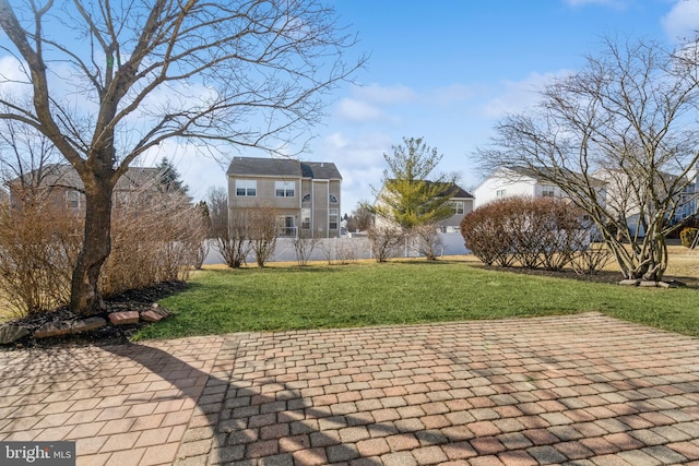 view of home's community featuring a lawn and a patio area