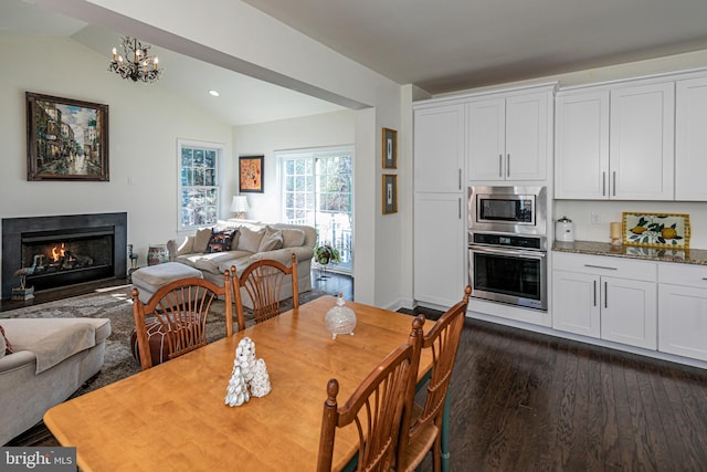 15 Milford Pl, Skillman, NJ 08558 - dining space with dark wood-type flooring, a notable chandelier, vaulted ceiling, and a fireplace with flush hearth