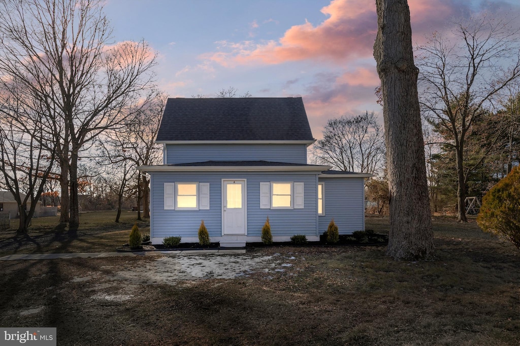 rear view of property featuring roof with shingles