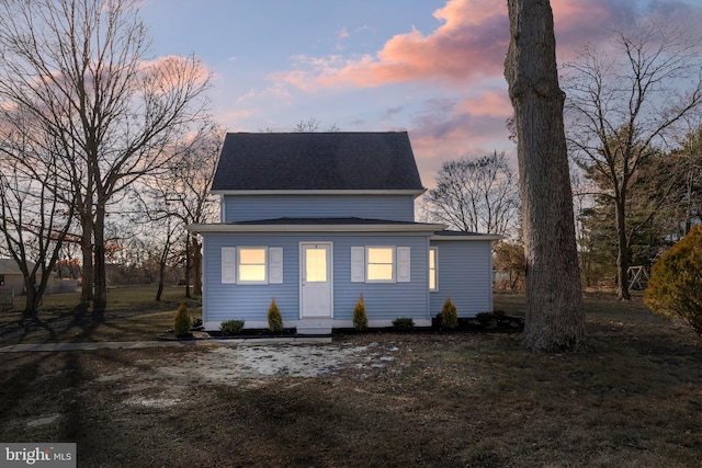 rear view of property featuring roof with shingles