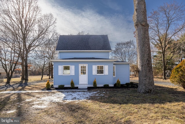 view of front facade featuring a front yard and roof with shingles