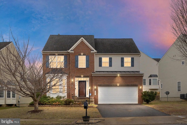 view of front of home with driveway, a garage, metal roof, a standing seam roof, and brick siding