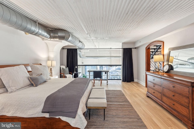 bedroom with light wood-type flooring and baseboards