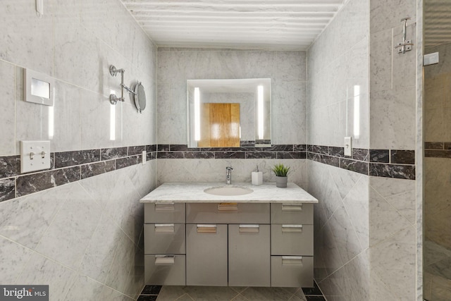 bathroom featuring tile patterned flooring, vanity, and tile walls