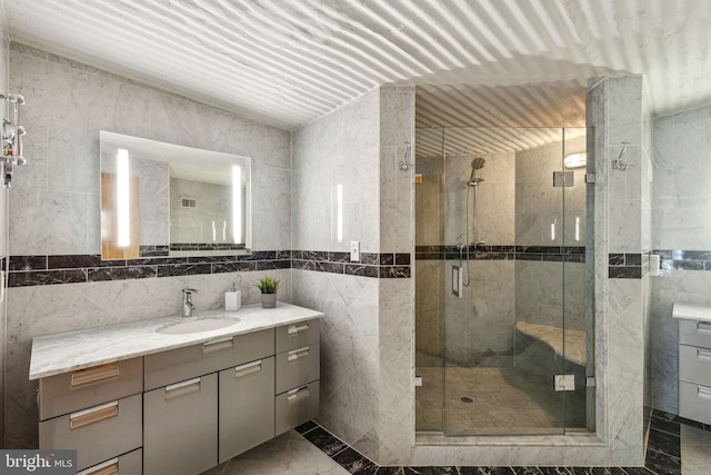 full bathroom featuring tile walls, vanity, and a shower stall