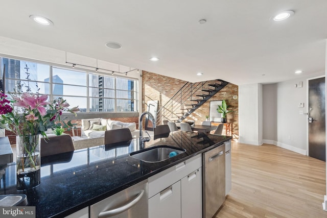 kitchen featuring recessed lighting, a sink, white cabinetry, dishwasher, and light wood finished floors