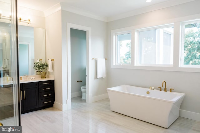 full bathroom featuring ornamental molding, a wealth of natural light, a freestanding bath, and vanity