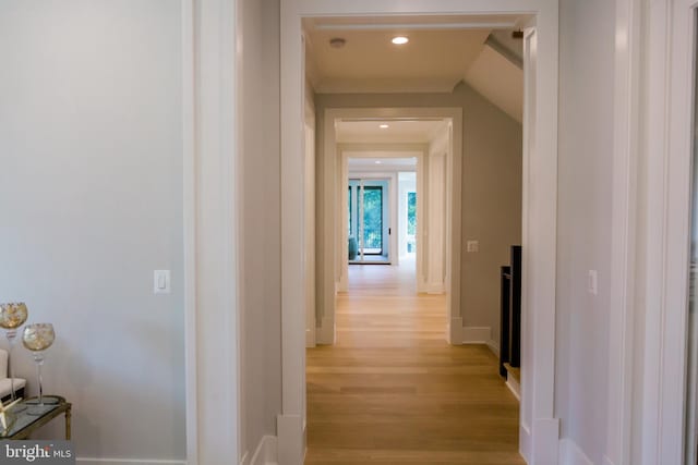 hallway with light wood finished floors, baseboards, and recessed lighting