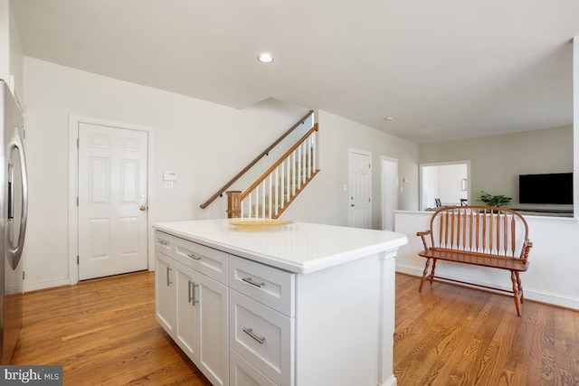 kitchen featuring light countertops, a center island, white cabinetry, and light wood finished floors