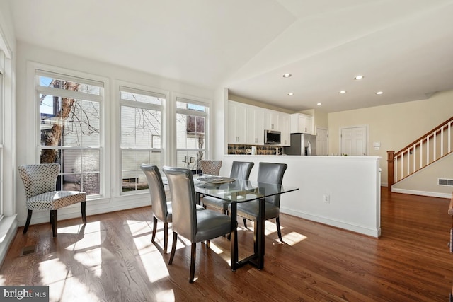 dining space featuring lofted ceiling, plenty of natural light, stairway, and dark wood-style flooring