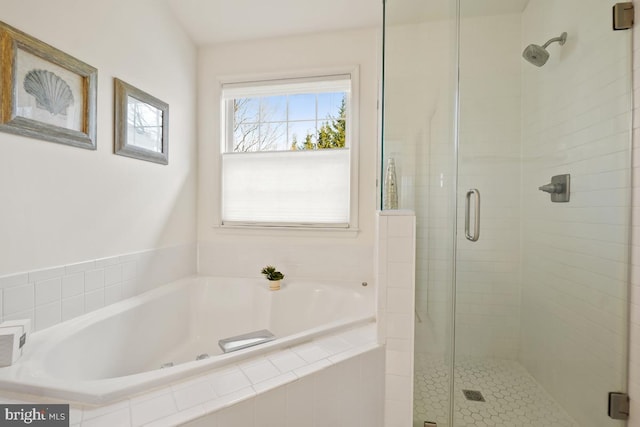 full bathroom featuring a garden tub and a shower stall