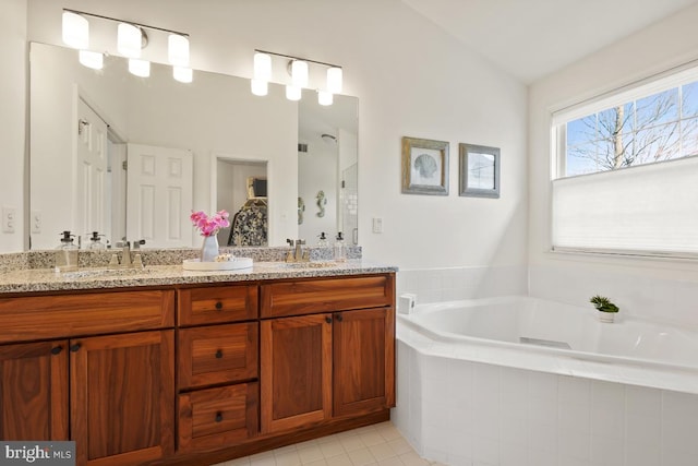 bathroom with vaulted ceiling, a garden tub, a sink, and double vanity