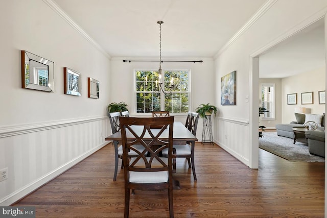 dining area featuring dark wood-style floors, ornamental molding, and wainscoting