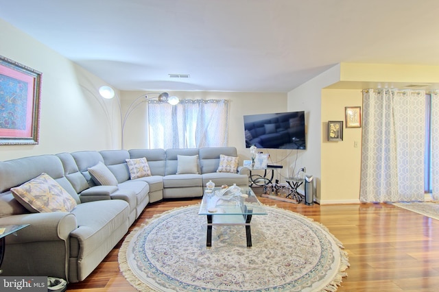 living area with visible vents and wood finished floors