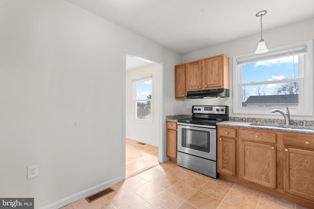 kitchen with visible vents, stainless steel electric stove, under cabinet range hood, pendant lighting, and a sink