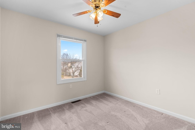 carpeted spare room featuring visible vents, ceiling fan, and baseboards