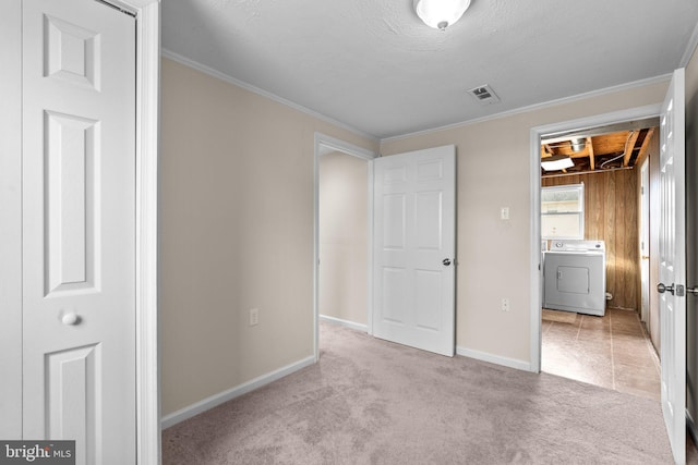 unfurnished bedroom with baseboards, washer / clothes dryer, visible vents, and light colored carpet