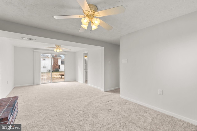 spare room with visible vents, light carpet, baseboards, and a textured ceiling