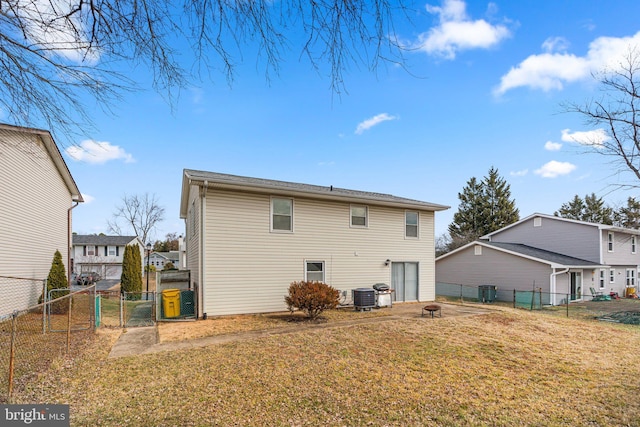 back of property featuring cooling unit, a gate, a fenced backyard, and a yard