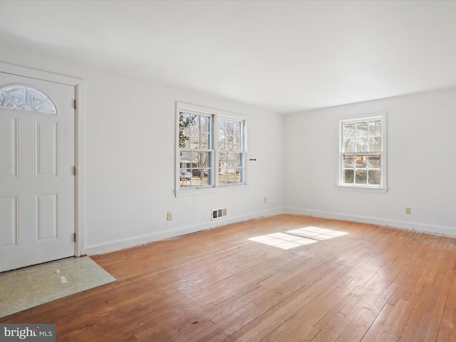 foyer entrance featuring a healthy amount of sunlight, visible vents, light wood-style flooring, and baseboards